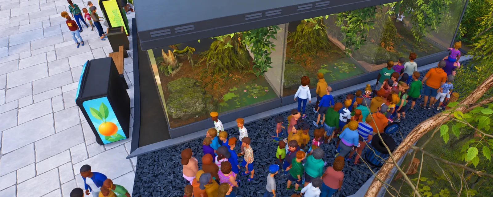 Visitors walking past glass exhibits and tropical planting in a zoo